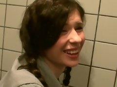 Two dicks are getting put inside a tiny woman in a public restroom